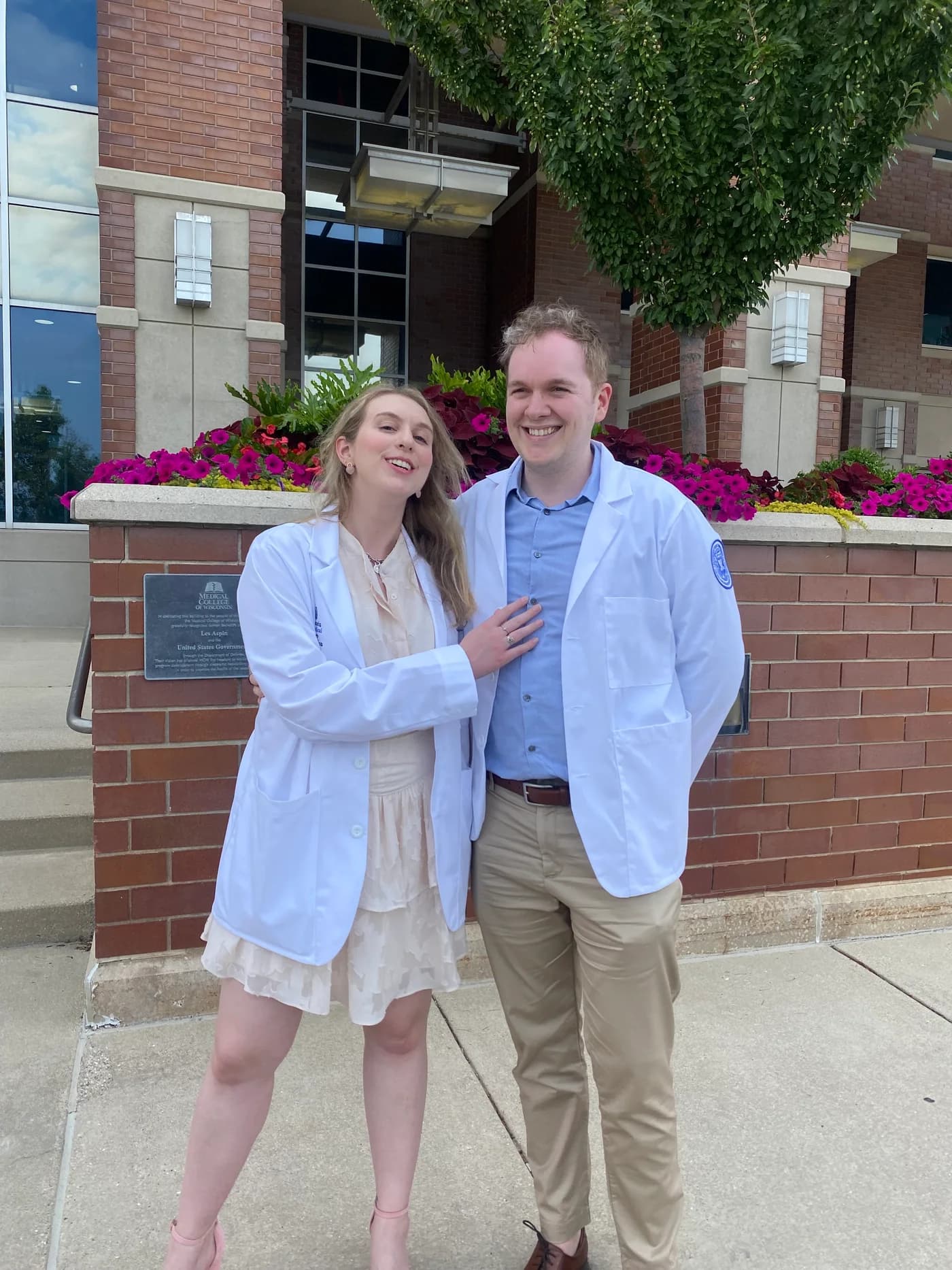 Jay and Gabi smiling together in white coats.